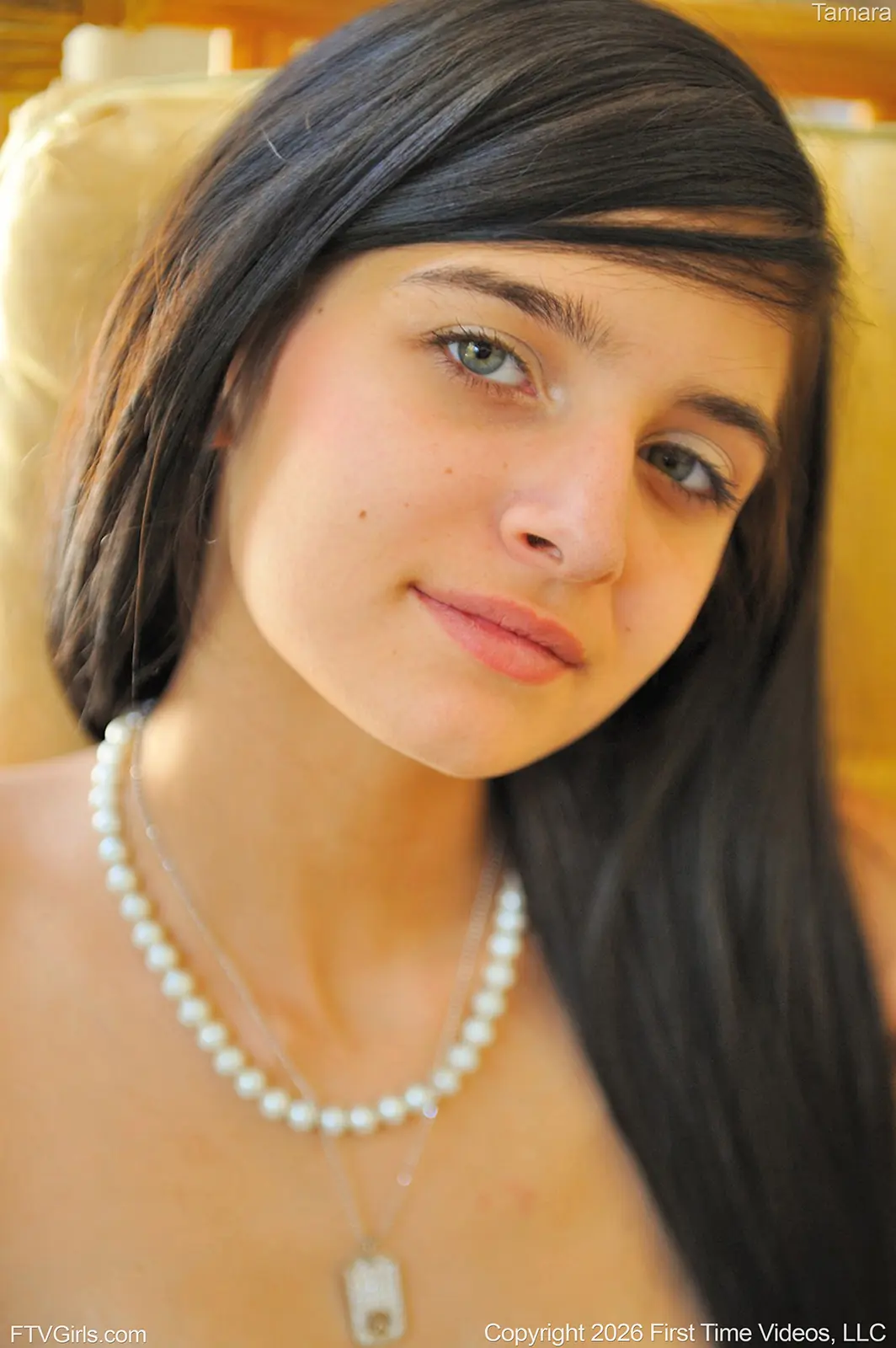 tamara-ftvgirls-green-eyes-pearl-necklace-portrait Close-up portrait of Tamara with green eyes, dark hair and a pearl necklace in warm indoor light